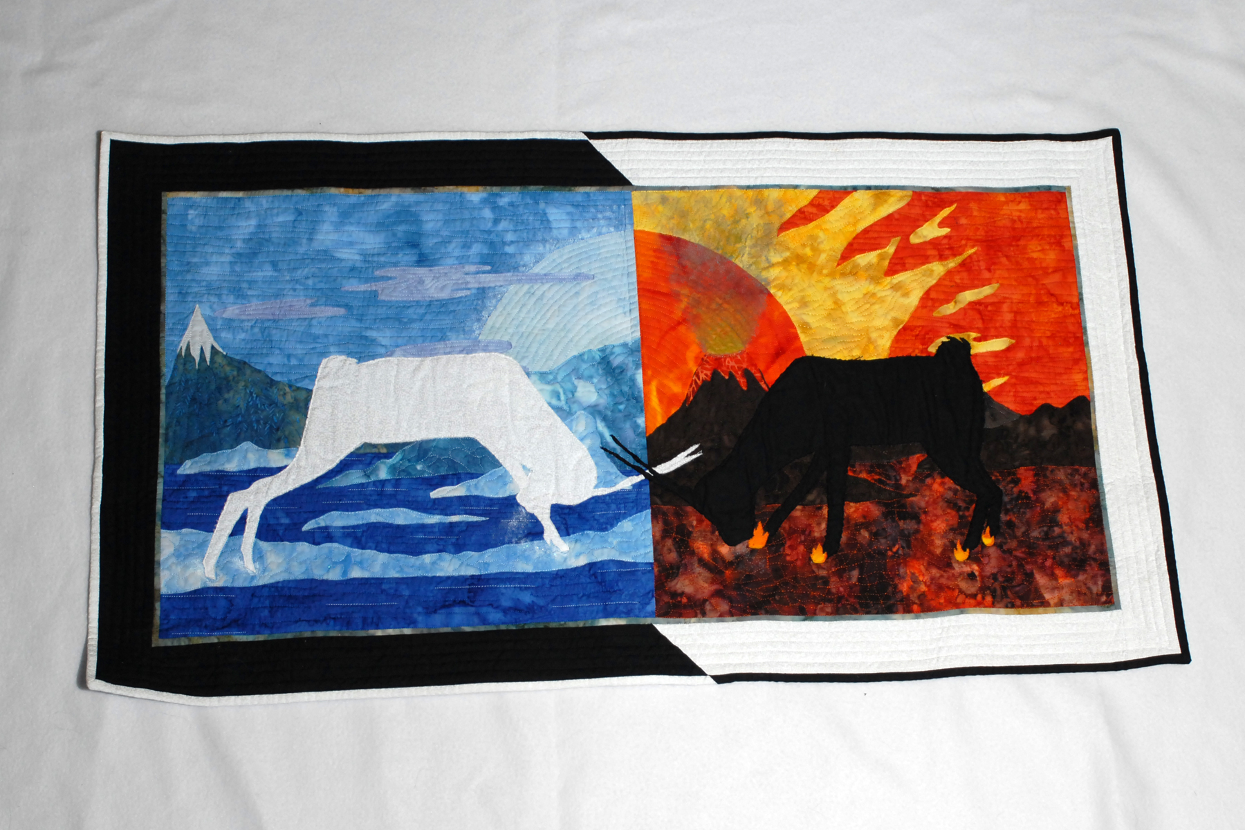 Quilted wall hanging of a white elk and black bull facing off