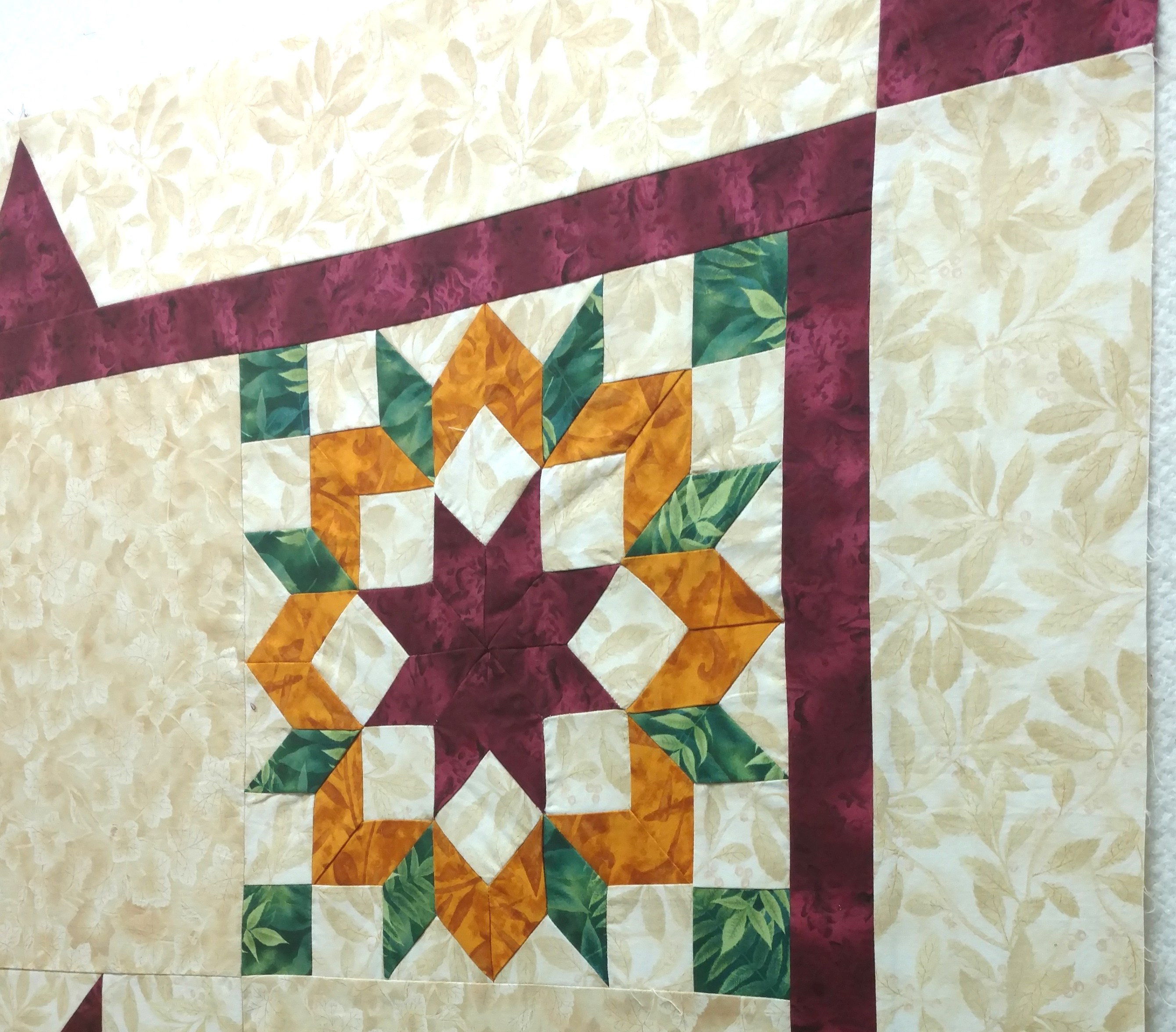Quilt with an orange, green and burgundy star block