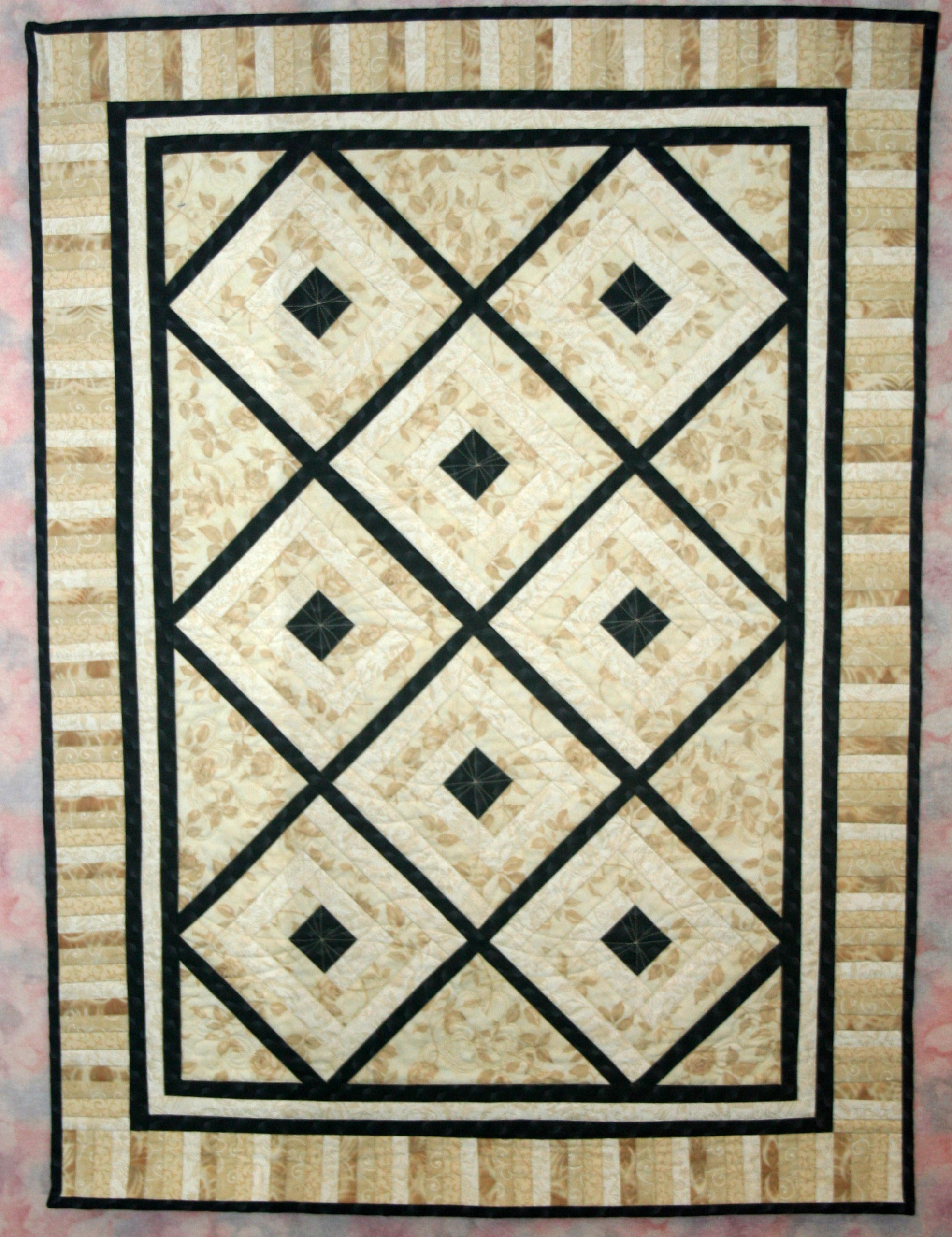 Black and white diamond lattice quilt with cream floral background